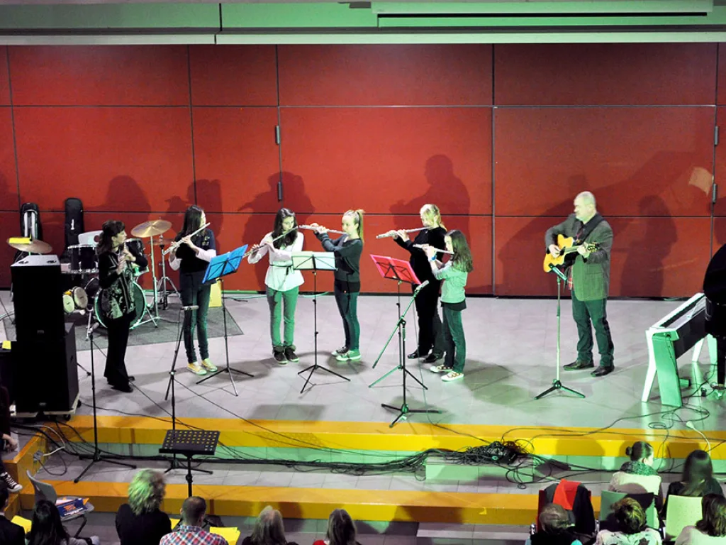 Musizierende stehen mit Instrumenten auf der Bühne.